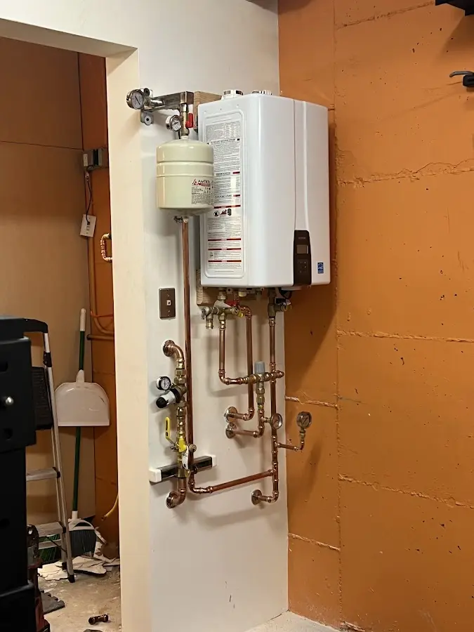 Plumbing technician inspecting water heater connections in Cynthiana